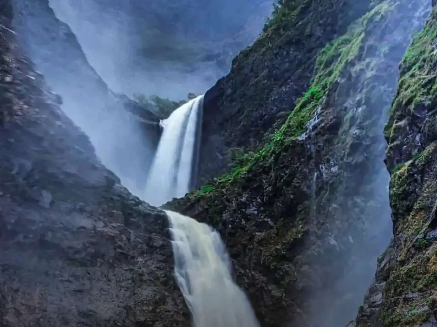 A trekker pointing at Kalu waterfall in Malshej Ghat